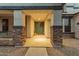 Inviting front porch featuring stone accents, a green front door with a wreath, and decorative elements at 3241 E Aris Dr, Gilbert, AZ 85298