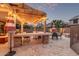 Inviting outdoor kitchen and entertaining area, complete with pergola, string lights, and outdoor seating at 3241 E Aris Dr, Gilbert, AZ 85298