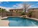 Inviting backyard pool with a rock waterfall feature and desert landscaping offers a serene retreat at 3241 E Aris Dr, Gilbert, AZ 85298
