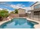 Lush backyard pool with black safety fence and desert landscaping offers a peaceful escape at 3241 E Aris Dr, Gilbert, AZ 85298