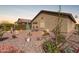 Serene backyard featuring a stone patio, desert landscaping, mature plants, and privacy at 514 S 224Th Dr, Buckeye, AZ 85326