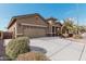 Tan house with a two-car garage and neatly landscaped yard at 514 S 224Th Dr, Buckeye, AZ 85326