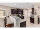 Granite kitchen island with seating, dark wood cabinets, and stainless steel appliances at 514 S 224Th Dr, Buckeye, AZ 85326