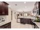 Modern kitchen features stainless appliances, granite counters, and dark wood cabinets at 514 S 224Th Dr, Buckeye, AZ 85326