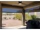 Covered patio area featuring ceiling fan, decorative outdoor fireplace, and view of landscaped backyard at 514 S 224Th Dr, Buckeye, AZ 85326
