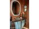 Unique powder room showcasing decorative wall treatment, artistic mirror, and custom vanity at 5526 E Roadrunner Rd, Paradise Valley, AZ 85253