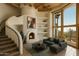 Inviting living room with fireplace, curved staircase, and large picture windows at 5526 E Roadrunner Rd, Paradise Valley, AZ 85253