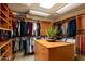 Spacious walk-in closet features built-in shelving, closet rods, and large center island for storage at 5526 E Roadrunner Rd, Paradise Valley, AZ 85253