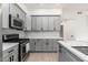 Modern kitchen with gray cabinets, white quartz countertops, and stainless steel appliances at 5550 N 16Th St # 102, Phoenix, AZ 85016