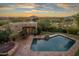 Stunning aerial view of a luxurious home with a pool and mountain views at sunset at 9950 E Sundance Trl, Scottsdale, AZ 85262