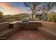 Outdoor kitchen with built-in grill and seating area at 9950 E Sundance Trl, Scottsdale, AZ 85262