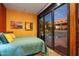 Guest bedroom with teal bedding and sliding glass doors to patio at 9950 E Sundance Trl, Scottsdale, AZ 85262