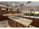 Gourmet kitchen features granite island, custom cabinetry, and a pot rack at 9950 E Sundance Trl, Scottsdale, AZ 85262