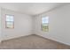 Bright and airy bedroom with two windows, plush carpet, and neutral wall color at 12362 W Marguerite Ave, Avondale, AZ 85323