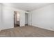 Bright bedroom featuring neutral carpet, white walls and trim, with a glimpse into an en-suite bath at 12362 W Marguerite Ave, Avondale, AZ 85323