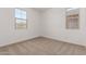 Bright and airy carpeted bedroom with two windows providing plenty of natural light at 12362 W Marguerite Ave, Avondale, AZ 85323