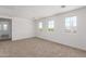 Spacious bedroom with neutral carpet, three large windows, and bright natural light at 12362 W Marguerite Ave, Avondale, AZ 85323