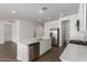 Open kitchen features stainless appliances, quartz counters, white cabinets, island with sink, and walk in pantry at 12362 W Marguerite Ave, Avondale, AZ 85323