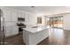 Bright kitchen showcases quartz counters, stainless appliances, white cabinets, and island overlooking the backyard at 12362 W Marguerite Ave, Avondale, AZ 85323