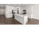 Bright kitchen with white cabinets, quartz countertops, stainless appliances, and an island with sink creates a modern, clean look at 12362 W Marguerite Ave, Avondale, AZ 85323