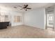 Bright living room with tile flooring, neutral walls, a ceiling fan, and natural light from the windows at 12739 W Merrell St, Avondale, AZ 85392