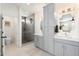 Bright bathroom with double sinks, gray cabinets, quartz countertops, a walk-in shower, and modern lighting at 1618 W Culver St, Phoenix, AZ 85007
