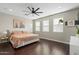 Spacious bedroom with hardwood floors, large windows, a ceiling fan, and a comfortable bed at 1618 W Culver St, Phoenix, AZ 85007