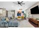 Open-concept living room featuring a modern ceiling fan, comfortable gray sectional, and colorful contemporary art at 1618 W Culver St, Phoenix, AZ 85007
