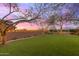 Landscaped backyard with artificial turf, string lights, and a brick patio at 18196 N 92Nd St, Scottsdale, AZ 85255