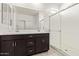 Bathroom with a double sink vanity, white countertop, and bright glass-enclosed shower at 18366 W Poston Dr, Surprise, AZ 85387