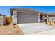 A cozy house featuring a well-maintained two-car garage and tidy front yard with minimalist desert landscaping at 18366 W Poston Dr, Surprise, AZ 85387