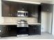 Modern kitchen featuring dark cabinetry, stainless steel appliances, and quartz countertops at 18366 W Poston Dr, Surprise, AZ 85387