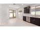 Bright kitchen area with stainless steel appliances, dark cabinetry, and an open layout with light flooring at 18366 W Poston Dr, Surprise, AZ 85387