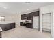 Modern kitchen featuring dark cabinets, stainless steel appliances, and an adjacent pantry and dining area at 18366 W Poston Dr, Surprise, AZ 85387