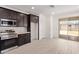 Kitchen with dark cabinets, stainless appliances, and sliding doors to the backyard and patio at 18366 W Poston Dr, Surprise, AZ 85387