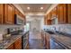 Condo kitchen with granite countertops, wood cabinets, and stainless steel appliances at 19878 N Star Ridge Dr, Sun City West, AZ 85375