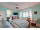 Primary bedroom with a large bed, rocking chair and ensuite bathroom access at 22 S Mesilla Ln, Casa Grande, AZ 85194