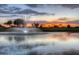 Sunset view of a lake with a fountain in a golf course community at 22 S Mesilla Ln, Casa Grande, AZ 85194