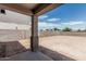 Covered patio area overlooking a spacious backyard with block wall at 22831 N 183Rd Dr, Surprise, AZ 85387