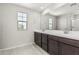 Bathroom featuring double sinks, large mirror, natural light, and wood-look flooring at 22831 N 183Rd Dr, Surprise, AZ 85387