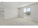 This bedroom features neutral carpet, white walls, a window and access to the laundry room at 22831 N 183Rd Dr, Surprise, AZ 85387