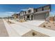 A row of inviting two-story homes each with a two-car garage, covered porch, and xeriscaped front yard at 22831 N 183Rd Dr, Surprise, AZ 85387