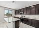 Modern kitchen boasting dark cabinets, stainless steel appliances, a center island, and white countertops at 22831 N 183Rd Dr, Surprise, AZ 85387