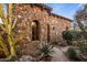 Stone exterior with arched windows and desert landscaping at 27256 N 97Th Pl, Scottsdale, AZ 85262