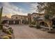 Tuscan style home with stone accents and a large driveway at 27256 N 97Th Pl, Scottsdale, AZ 85262