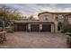 Three car garage with dark brown doors and stone facade at 27256 N 97Th Pl, Scottsdale, AZ 85262