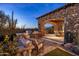 Outdoor kitchen and patio area with seating and desert landscape views at 27256 N 97Th Pl, Scottsdale, AZ 85262