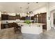 Spacious kitchen boasts granite countertops, dark wood cabinets, and a large island at 3171 N 159Th Ave, Goodyear, AZ 85395