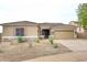 Single-story home with tan exterior, stone accents, and a two-car garage at 34910 N 27Th Ave, Phoenix, AZ 85086