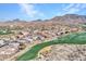 Aerial view of the house and surrounding golf course community in the mountains at 41933 N Crooked Stick Rd, Anthem, AZ 85086